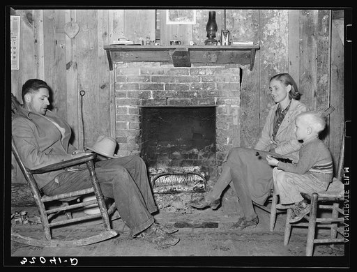 Tenant farmer and family sitting in front of fireplace of old home. They will be FSA (Farm Security Administration) clients on Sunflower Plantation, Mississippi