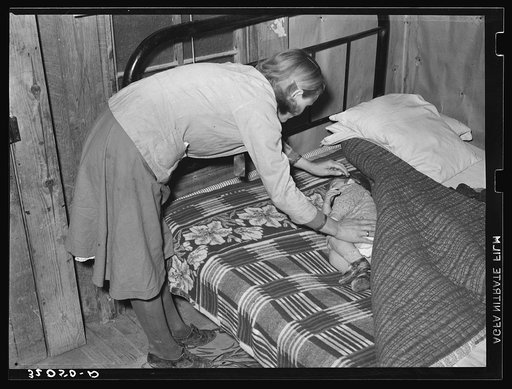 Wife of sharecropper putting baby to sleep near Pace, Mississippi. Background photo, Sunflower Plantation
