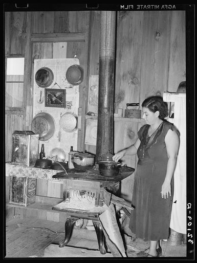 Wife of Mexican farm owner in kitchen. Hidalgo County, Texas