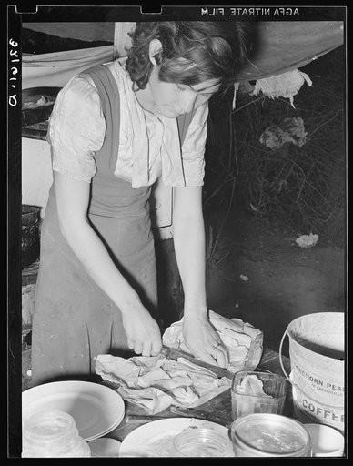 Married daughter of white migrant worker cutting salt meat for dinner. Near Harlingen, Texas (see 32108-D)