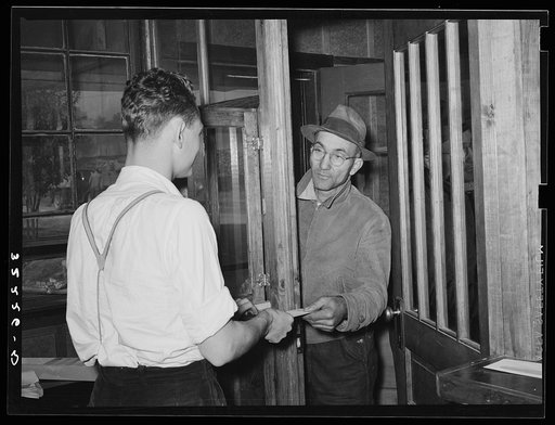 Farmer receiving check for sweet potatoes at starch plant. Laurel, Mississippi