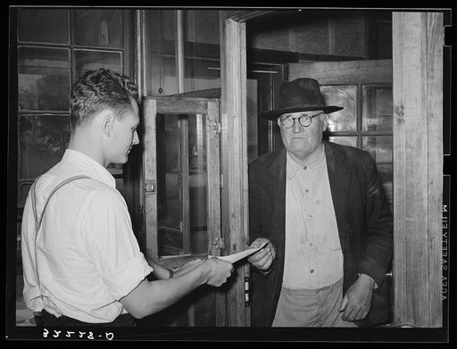 Farmer receiving check for sweet potatoes at starch plant. Laurel, Mississippi