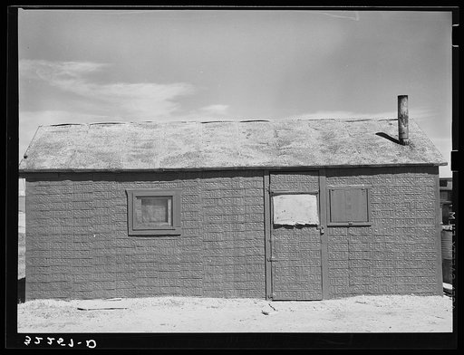 House in shantytown on Nueces Bay, Corpus Christi, Texas. Notice siding of old automobile license plates. House is occupied by migrant workers