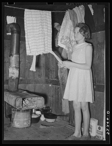 Untitled photo, possibly related to: Mexican girl standing over pan of hot coal in which pail of water is heating. Robstown, Texas