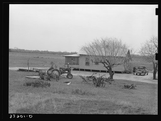 Untitled photo, possibly related to: Farmhouse of small farmer near Santa Rosa, Texas. Tractor and rusting farm implements are in the yard, showing the changes in farming methods and also demonstrating that even the small farmers are using the new tractors and other mechanized equipment