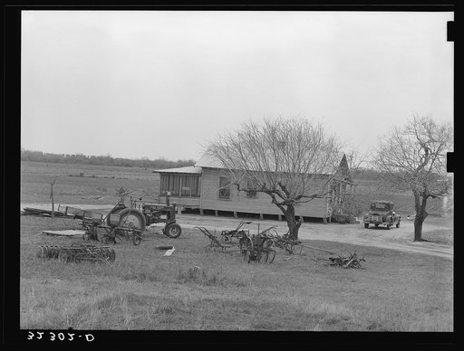 Farmhouse of small farmer near Santa Rosa, Texas. Tractor and rusting farm implements are in the yard, showing the changes in farming methods and also demonstrating that even the small farmers are using the new tractors and other mechanized equipment