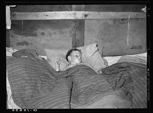 Untitled photo, possibly related to: A sick child sleeping in trailer home of his father near Sebastian, Texas. This family was originally from Iowa but had been in Texas doing migrant work the the last several years. They had found no work in the valley