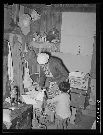 Mexican mother in crowded home. Notice the covered windows. Crystal City, Texas