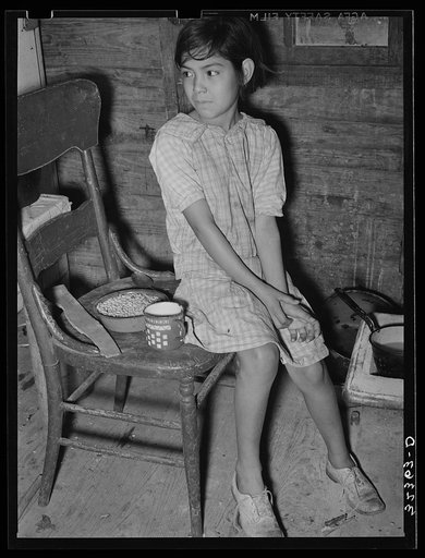 Mexican child with dried beans which play a large part in the Mexican diet. Crystal City, Texas
