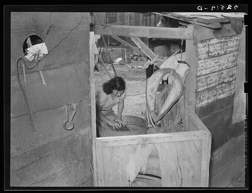 Mexican woman washing clothes in back of house. San Antonio, Texas