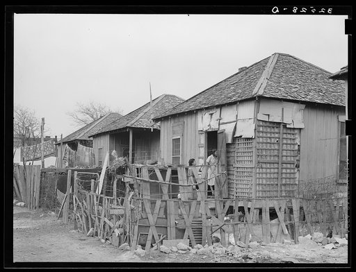 Row of Mexican houses. San Antonio, Texas. Notice crude fences and state of disrepair of houses