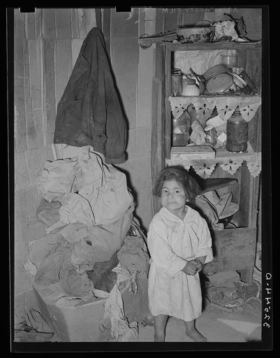 Mexican child in corner of living room. San Antonio, Texas