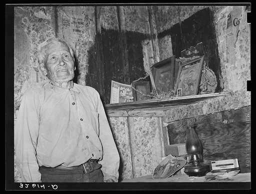 Mexican man in corner of living room. San Antonio, Texas