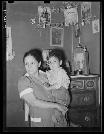 Mexican mother and child in front of shrine in corner of room. San Antonio, Texas