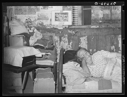Mexican woman resting on bed in her home. San Antonio, Texas