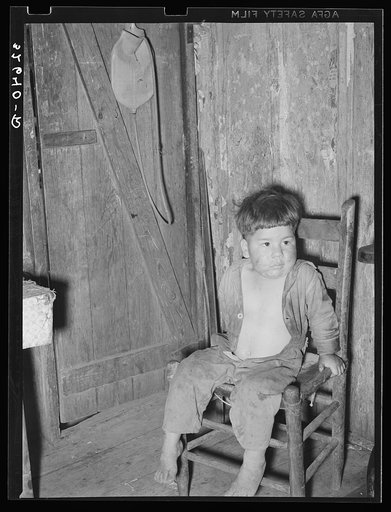 Mexican boy in corner of room. San Antonio, Texas