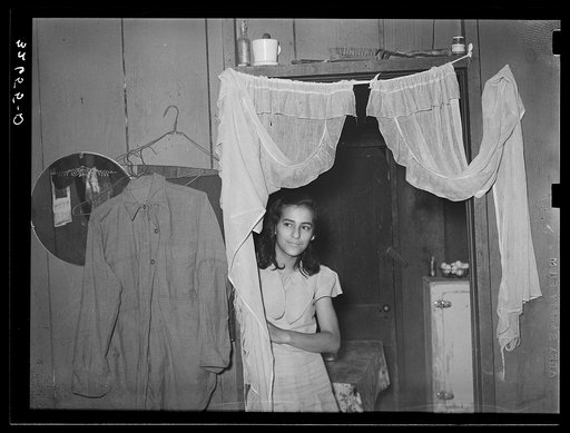 Mexican girl in doorway between living room and kitchen. San Antonio, Texas