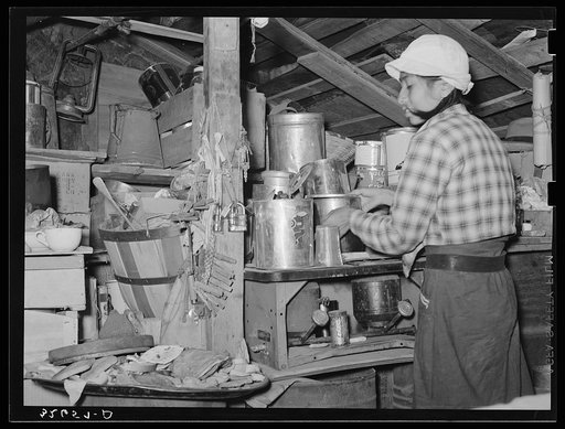 Mexican woman arranging things in her shack home. San Antonio, Texas