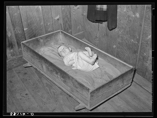 Baby of family living on relief. Notice the homemade cradle. Near Jefferson, Texas. Housing conditions in this section are particularly bad