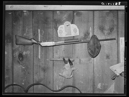 Rifle above bed in relief familiy's home near Jefferson, Texas