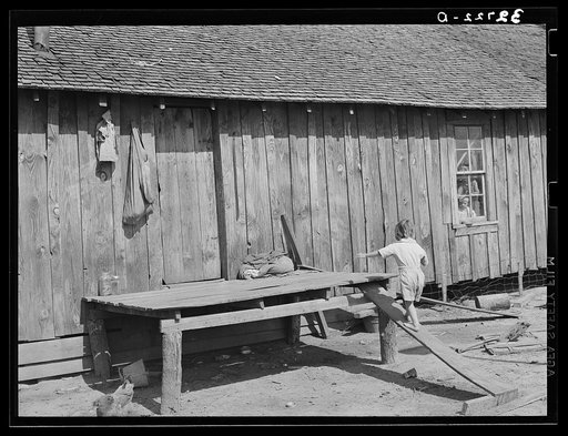 Child walking up improvised stairway on back of his home near Jefferson, Texas. Housing conditions are bad throughout this section