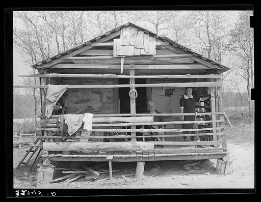 Old farmer and his wife on front porch of their home near Marshall, Texas