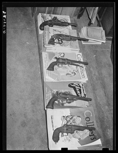 Magazines weighted down with pistols. Drugstore, Gonzales, Texas