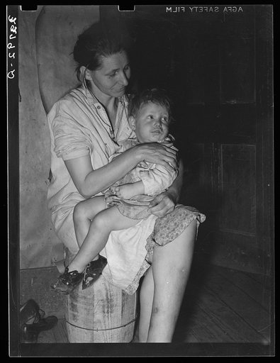 Mother and child. This woman, wife of an ex-farmer now living on relief, had pellagra in an advanced stage. She has had some treatment and shown great improvement but there were still evidences of mental disturbance.  She was the mother of twelve children. The child in her arms has malaria as have p