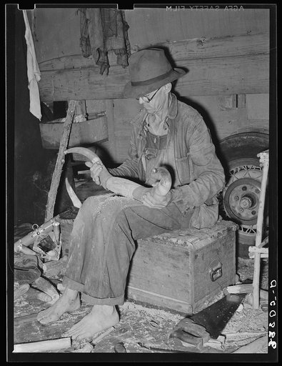 White migrant worker fitting horn onto wooden base near Hammond, Louisiana