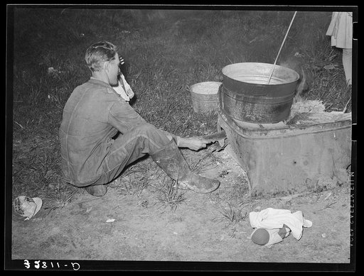 Untitled photo, possibly related to: Migratory berry picker putting trash into fire. Near Ponchatoula, Louisiana