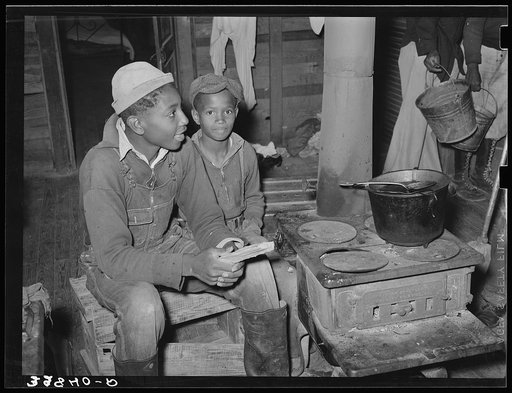 Untitled photo, possibly related to: Group of Negro berry pickers huddled around the stove trying to keep warm on a cold day in the berry picking season. Near Independence, Louisiana