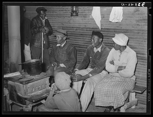 Group of Negroes around stove on a cold day in the strawberry picking season. Near Independence, Louisiana
