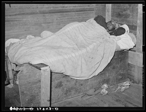 Negro woman sick in bed in strawberry pickers' quarter. Independence, Louisiana