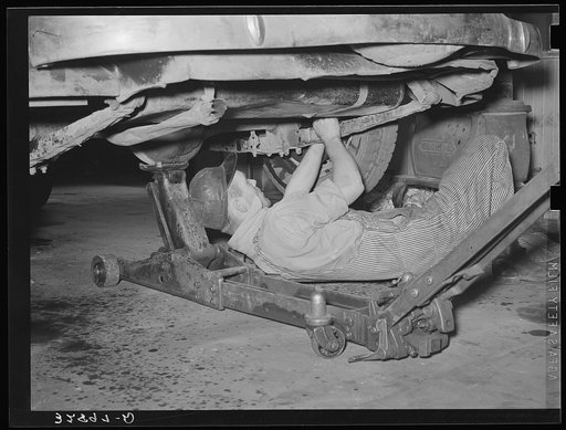Working on an automobile in a garage. San Augustine, Texas