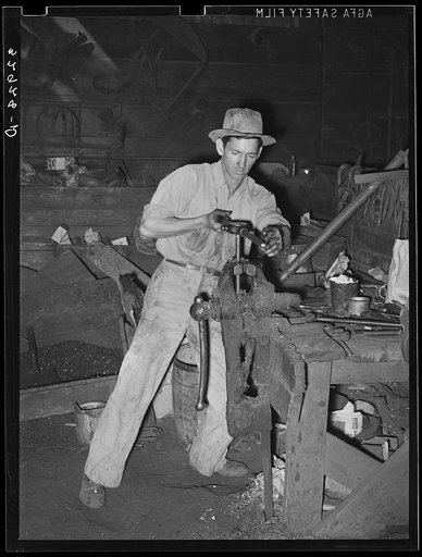 Threading a pipe at blacksmith shop. San Augustine, Texas