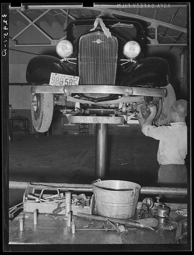Greasing automobile in garage. San Augustine, Texas