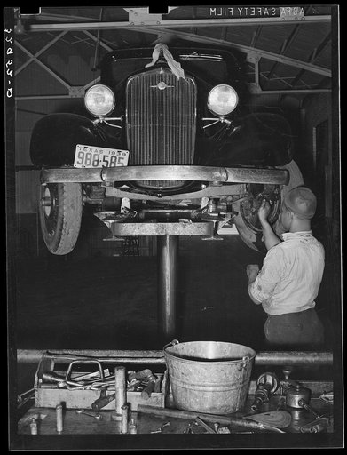 Greasing automobile in garage. San Augustine, Texas
