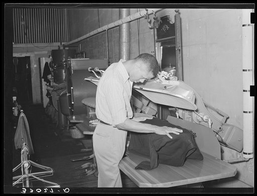 Pressing a coat in tailor shop. San Augustine, Texas