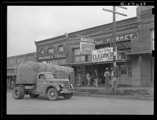 Wholesale grocery truck in front of grocery store. San Augustine, Texas