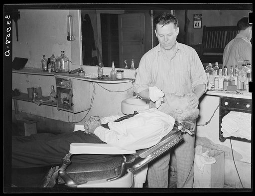 Barber applying finishing touches to a shave. San Augustine, Texas