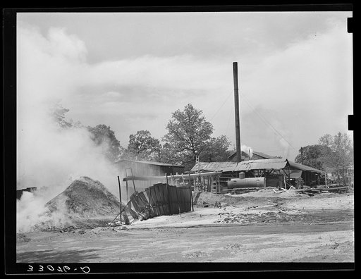 Burning pile of sawdust at sawmill at Wells, Texas