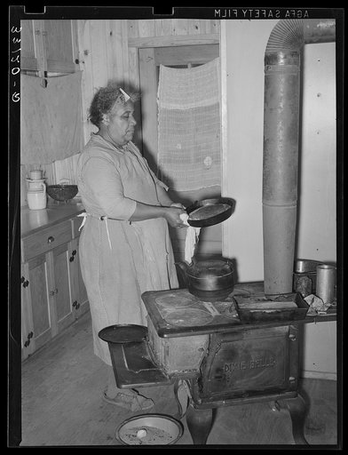 FSA (Farm Security Administration) client making bread in farm home. Sabine Farms, Marshall, Texas