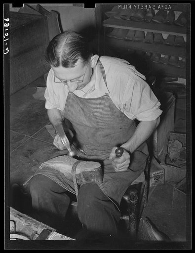 Untitled photo, possibly related to: Bootmaker pounding wooden peg into sole of boot in building up sole with several pieces of leather. Cowboy boot shop, Alpine, Texas