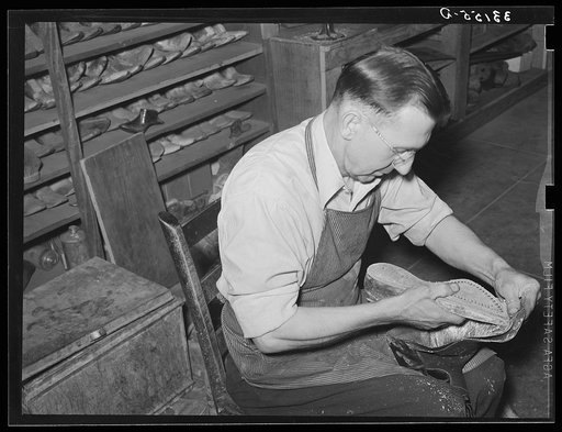 Bootmaker putting last and sole into upper part of boot. Boot shop, Alpine, Texas