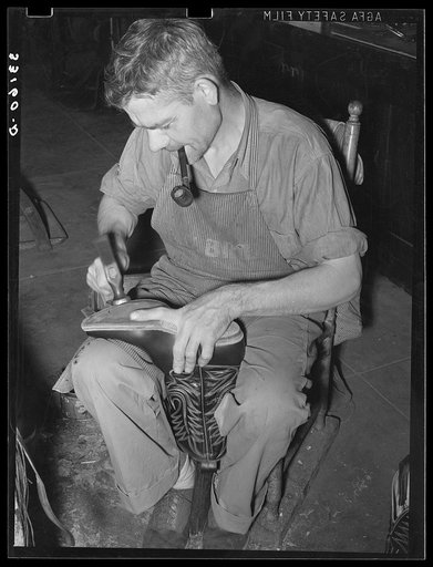 Bootmaker shaping the outer sole to the boot. Cowboy boot shop, Alpine, Texas