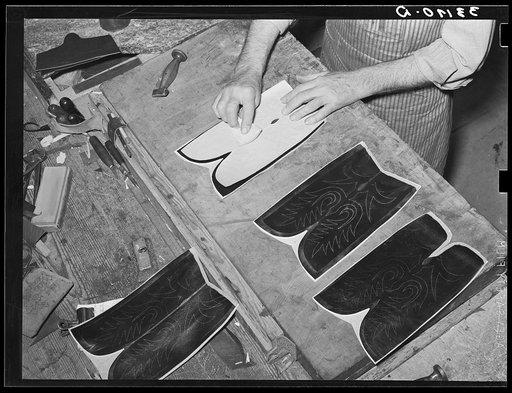 The pattern for the stitching on the uppers is transferred to the leather by means of talc through perforations in the pattern. Boot making shop, Alpine, Texas. Each of the bootmakers has his own patterns which he has fashioned