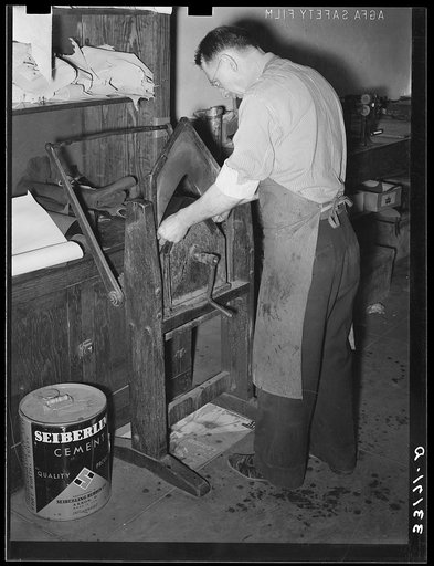 Placing pieces of leather into crimping machine to shape the lowers of the boots. Boot shop, Alpine, Texas