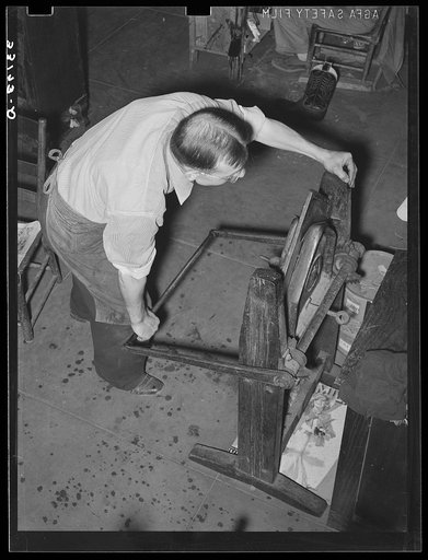 Crimping is accomplished by pulling down the lever on the crimping machine. Bootmaking shop, Alpine, Texas
