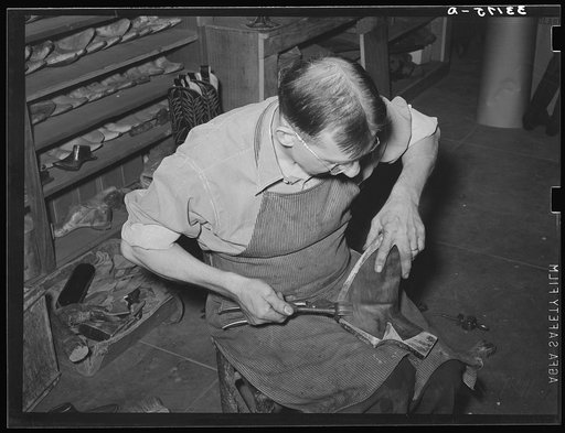 Drawing the lower of the boot over the last in order to assure perfect fit. Cowboy boot shop, Alpine, Texas