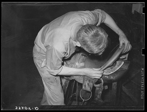 Shaping piece of leather around rim of saddle before sewing. Saddle shop, Alpine, Texas